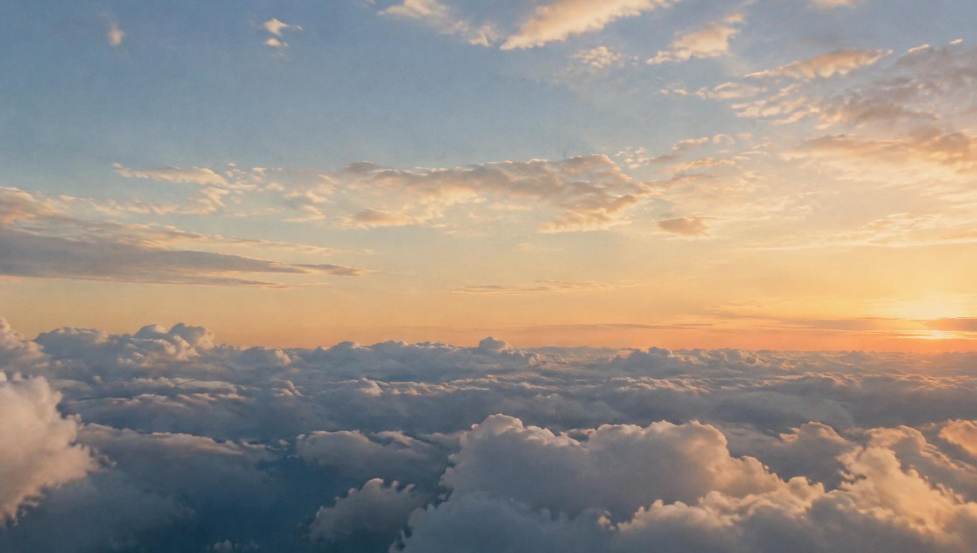 Soft sunrise sky above a sea of clouds
